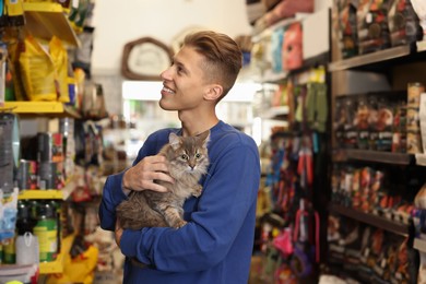 Photo of Man with his cute cat in pet shop