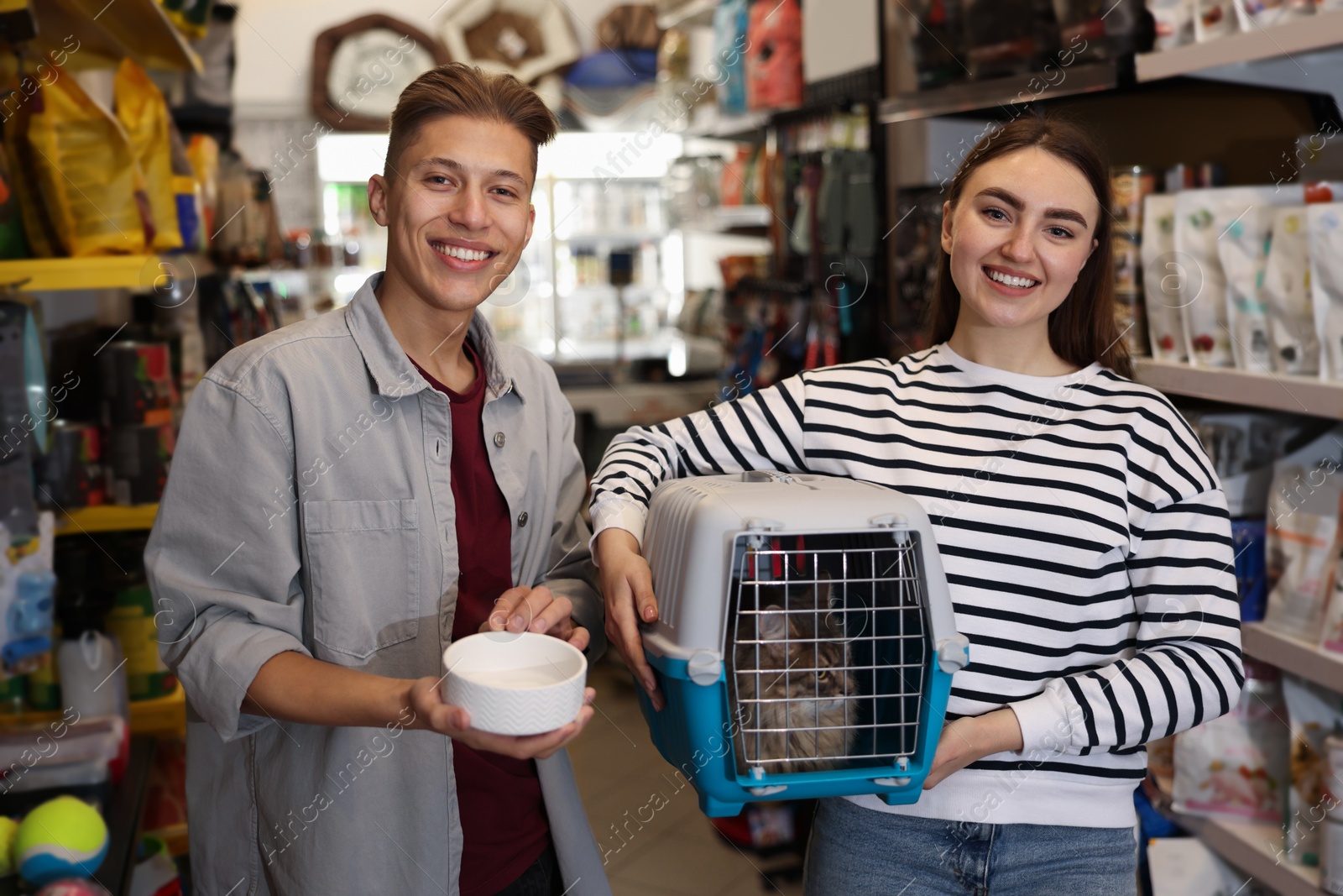 Photo of Couple choosing feeding bowl for their cat in pet shop