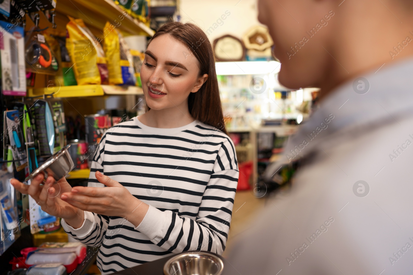 Photo of Man and woman choosing bowl in pet shop, selective focus