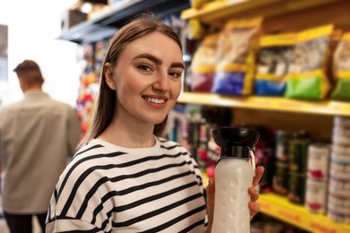 Photo of Woman with dog water bottle in pet shop