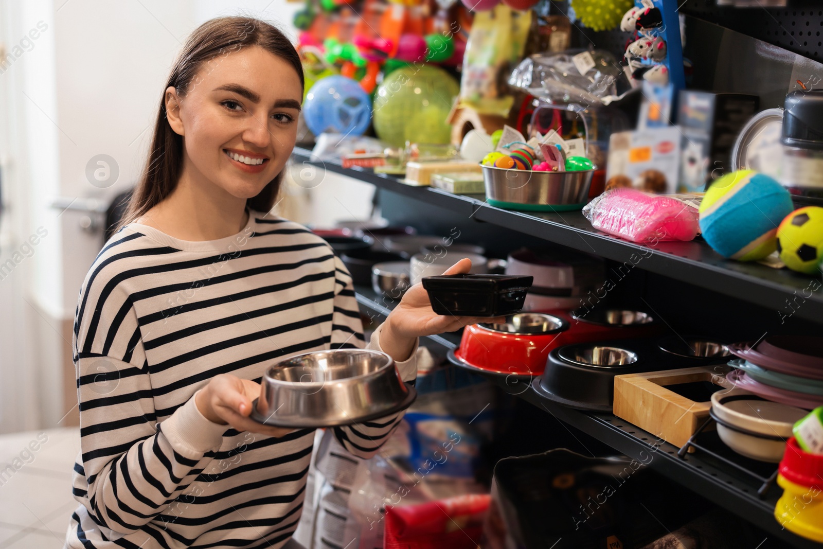 Photo of Woman choosing feeding bowl in pet shop