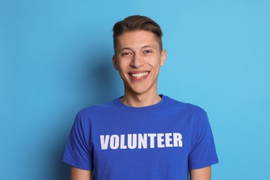 Photo of Portrait of smiling volunteer on light blue background