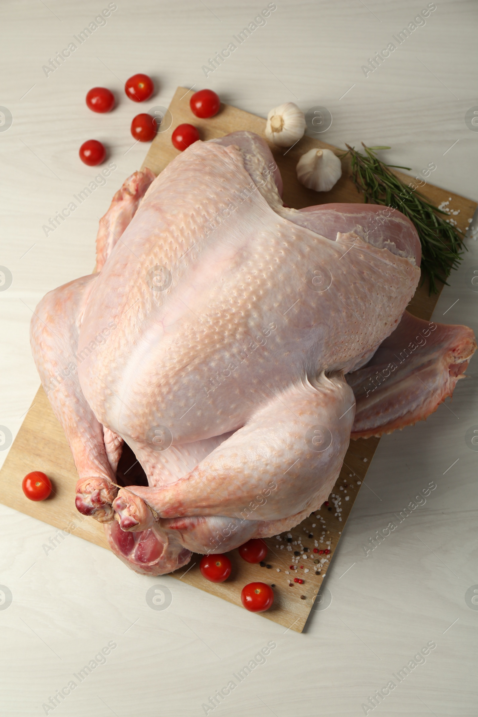 Photo of Whole raw turkey and ingredients on white wooden table, flat lay