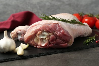 Photo of Raw turkey drumsticks and ingredients on grey table, closeup