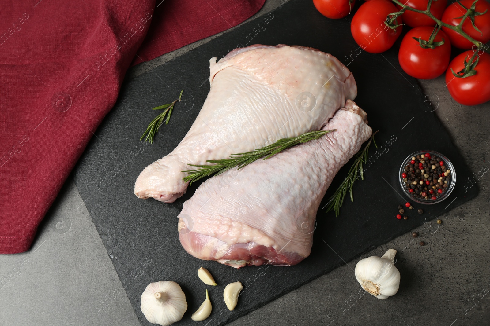 Photo of Raw turkey drumsticks and ingredients on grey table, flat lay