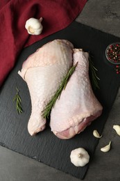 Photo of Raw turkey drumsticks and ingredients on grey table, flat lay