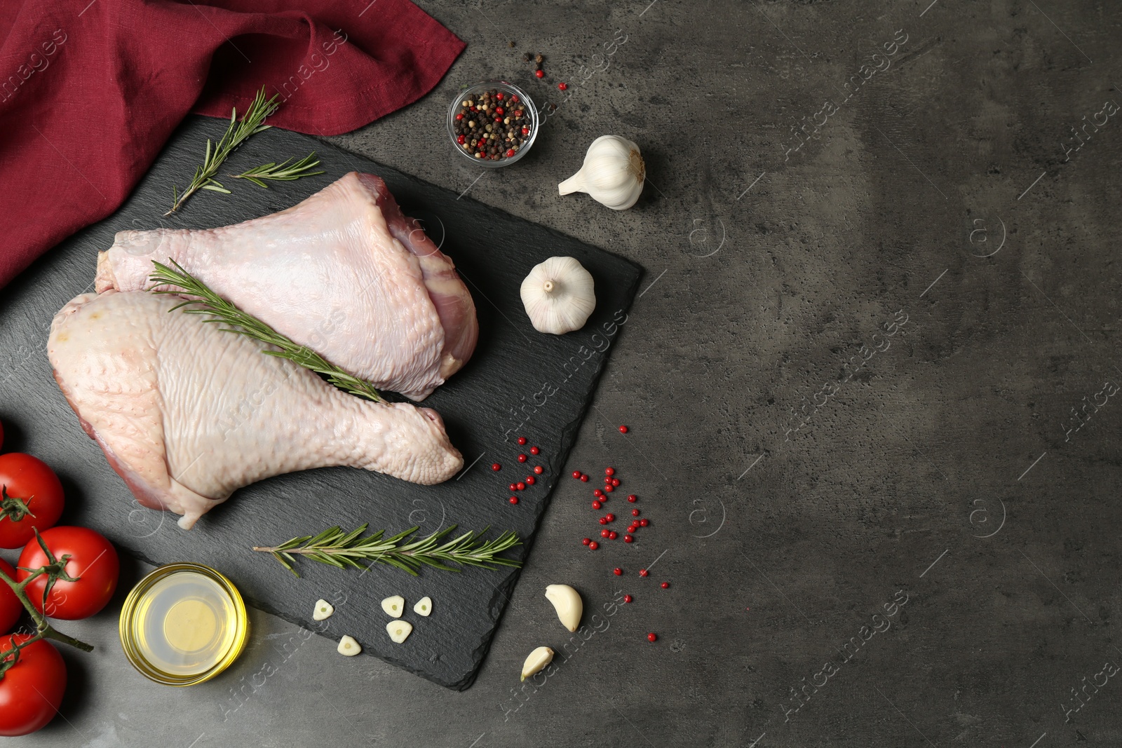 Photo of Raw turkey drumsticks and ingredients on grey table, flat lay. Space for text