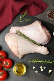 Photo of Raw turkey drumsticks and ingredients on grey table, flat lay