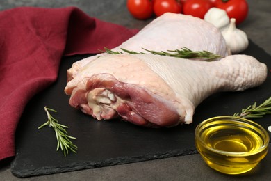 Photo of Raw turkey drumsticks and ingredients on grey table, closeup