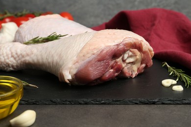 Photo of Raw turkey drumsticks and ingredients on grey table, closeup