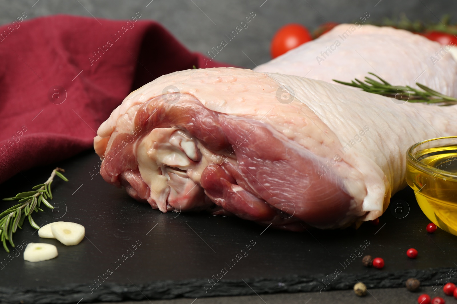 Photo of Raw turkey drumsticks and ingredients on grey table, closeup