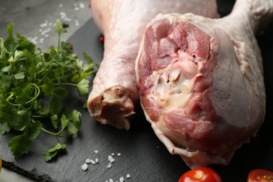 Photo of Raw turkey drumsticks and ingredients on grey table, closeup