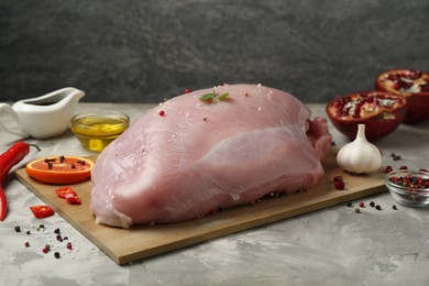 Photo of Raw turkey breast and ingredients for marinade on grey textured table