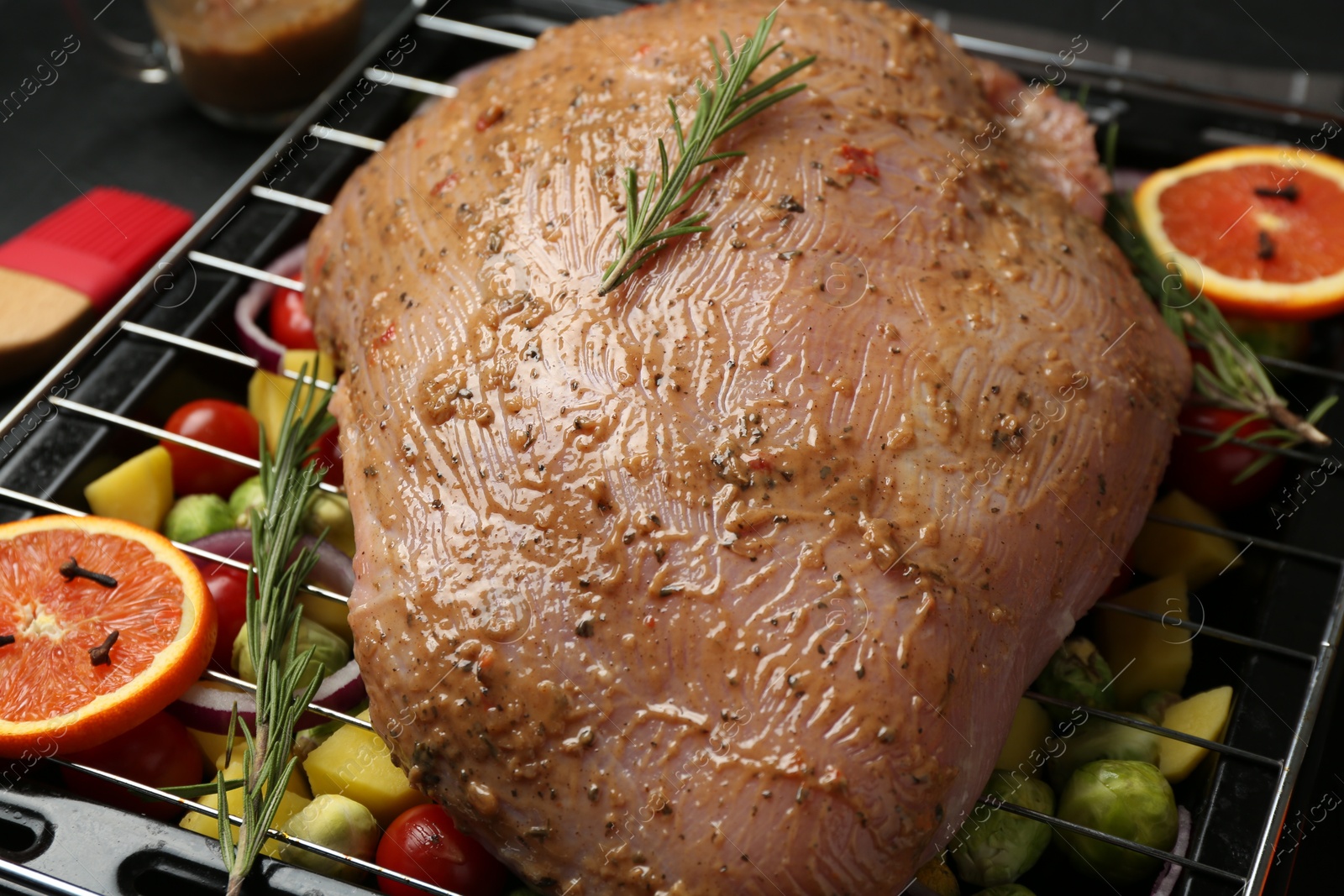 Photo of Raw turkey breast with marinade and ingredients on table, closeup