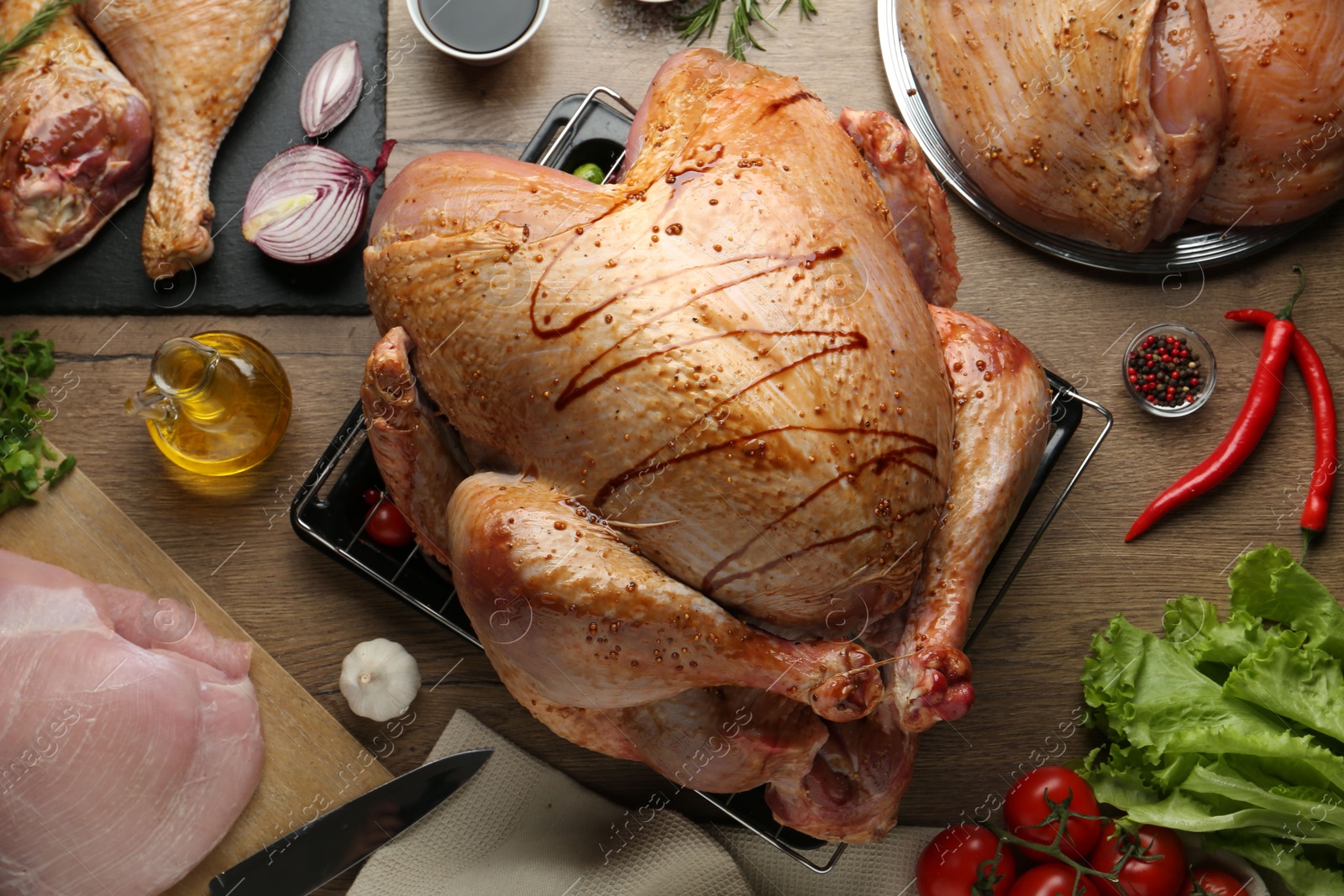 Photo of Raw marinated turkey meat and products on wooden table, flat lay