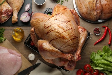 Photo of Raw marinated turkey meat and products on wooden table, flat lay