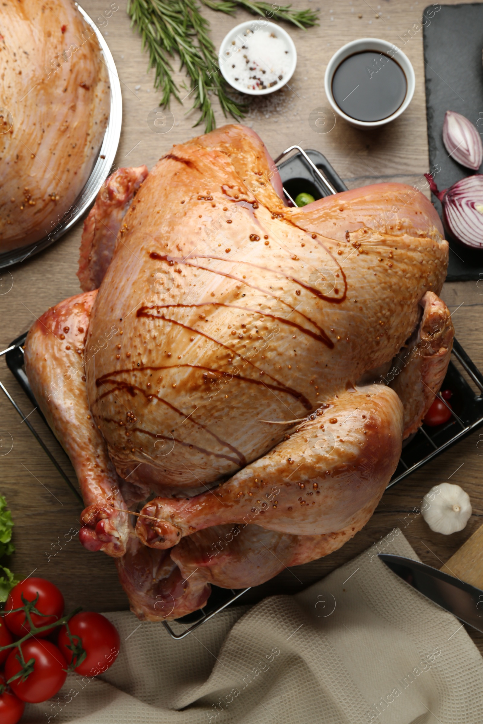 Photo of Raw marinated turkey meat and products on wooden table, flat lay