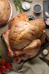 Photo of Raw marinated turkey meat and products on wooden table, flat lay