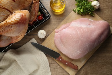 Photo of Raw turkey meat, products and knife on wooden table, flat lay