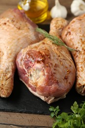 Photo of Raw marinated turkey drumsticks on wooden table, closeup