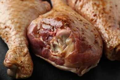 Photo of Raw marinated turkey drumsticks on table, closeup