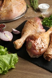 Photo of Raw marinated turkey drumsticks on wooden table