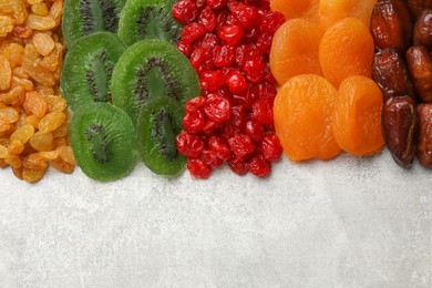 Photo of Different dried fruits on grey table, top view. Space for text