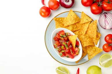 Photo of Delicious salsa (Pico de gallo) served with nachos and products on white wooden table, flat lay. Space for text