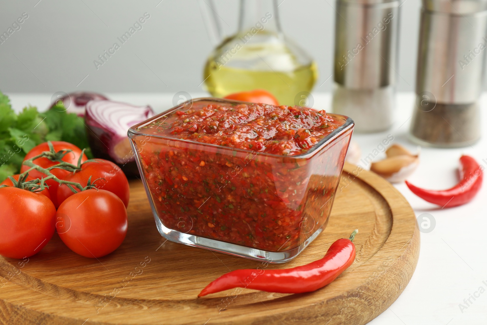 Photo of Delicious salsa sauce and ingredients on white table, closeup