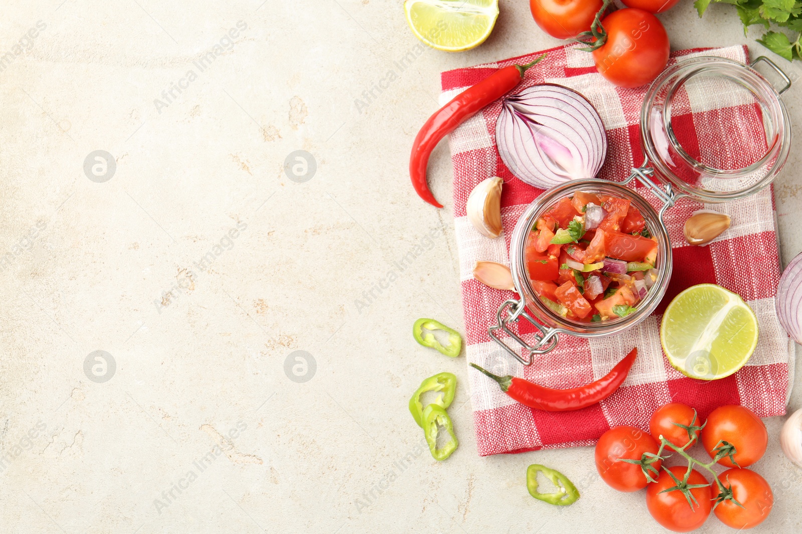 Photo of Delicious salsa (Pico de gallo) in jar and ingredients on light textured table, flat lay. Space for text