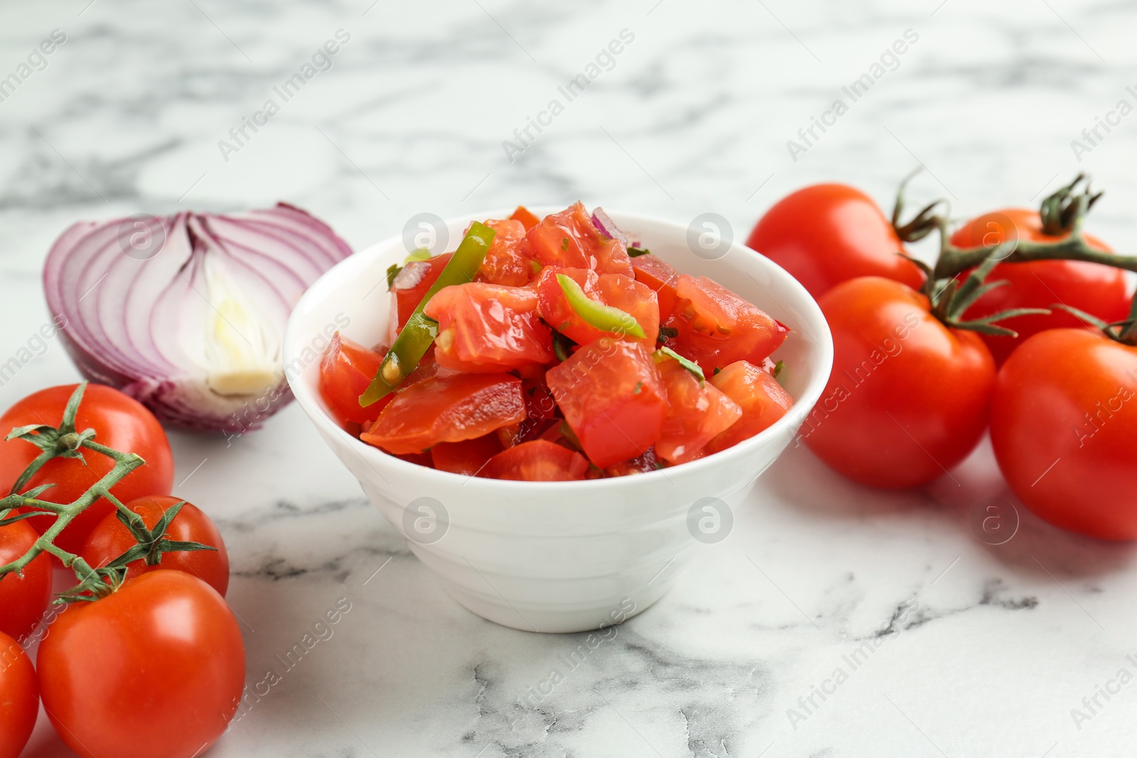 Photo of Delicious salsa, onion and tomatoes on white marble table, closeup