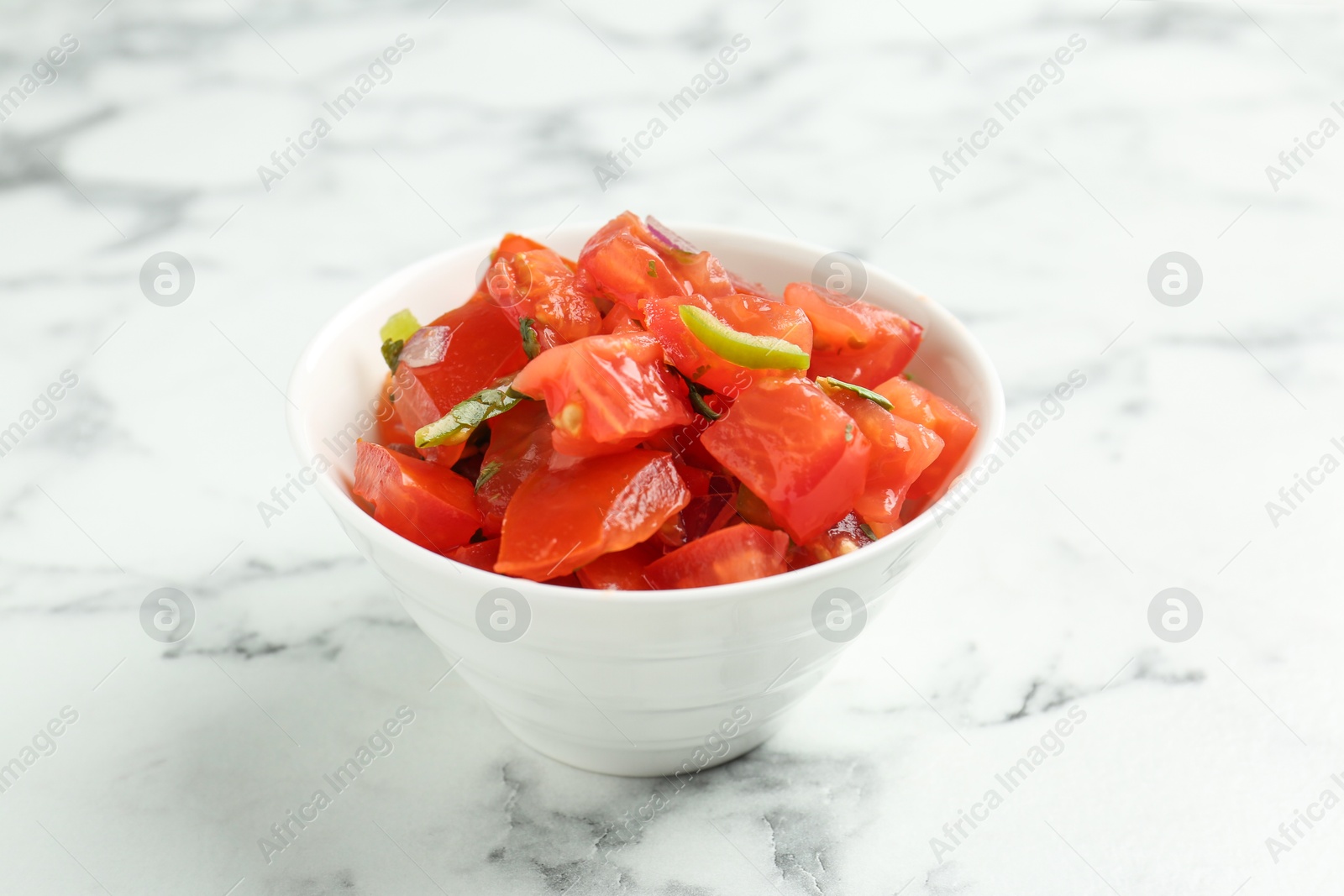 Photo of Delicious salsa on white marble table, closeup