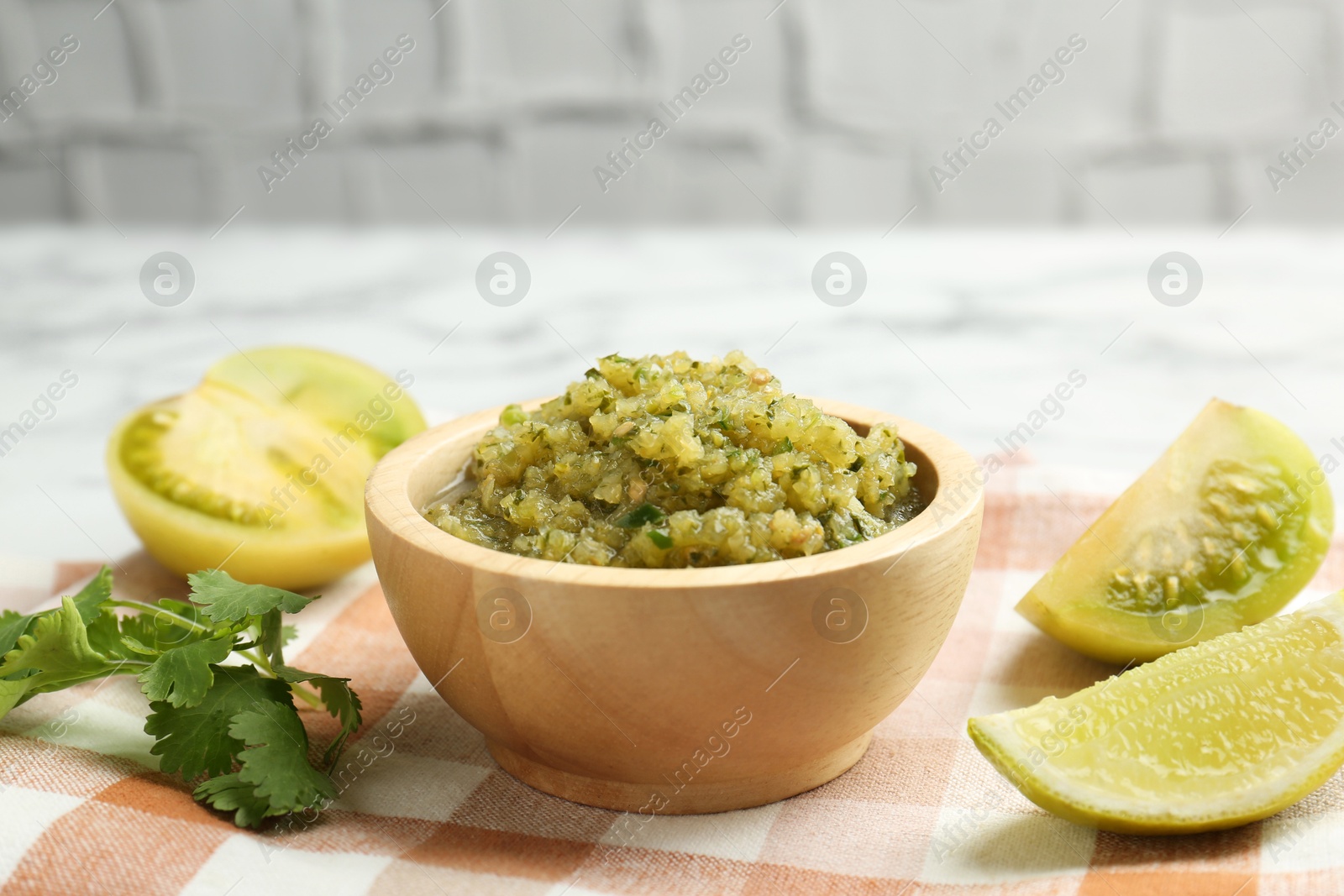 Photo of Spicy salsa and ingredients on table, closeup