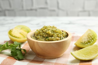 Photo of Spicy salsa and ingredients on table, closeup