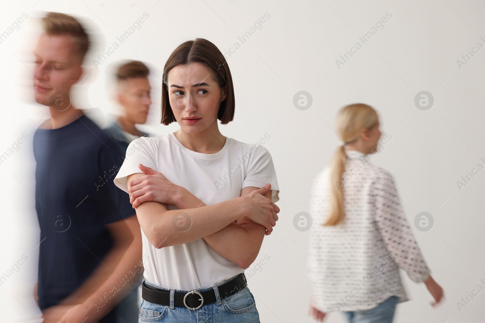 Photo of Young woman feeling uncomfortable among people indoors