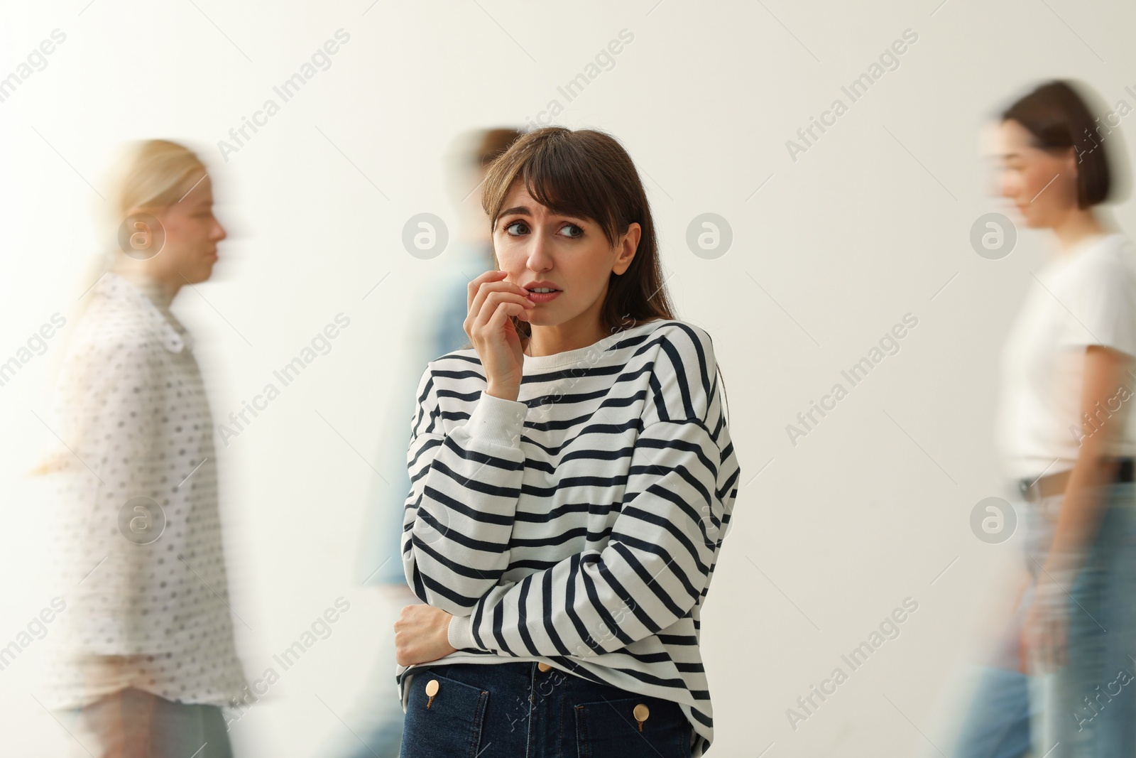 Photo of Young woman feeling uncomfortable among people indoors