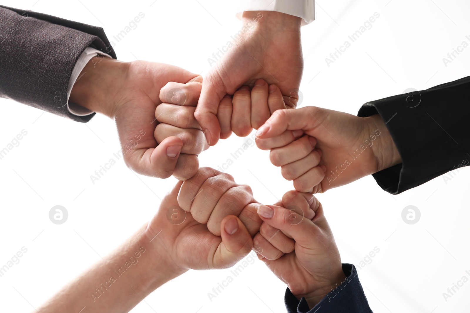 Photo of Teamwork. Group of people joining fists together indoors, bottom view