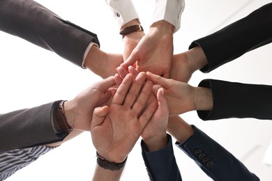 Photo of Teamwork. Group of people joining hands together indoors, bottom view