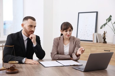 Photo of Man having meeting with professional notary at wooden desk indoors