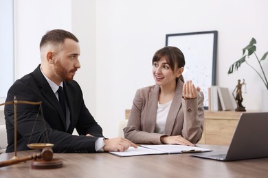 Photo of Man having meeting with professional notary at wooden desk indoors