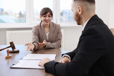 Man having meeting with professional notary at wooden desk indoors