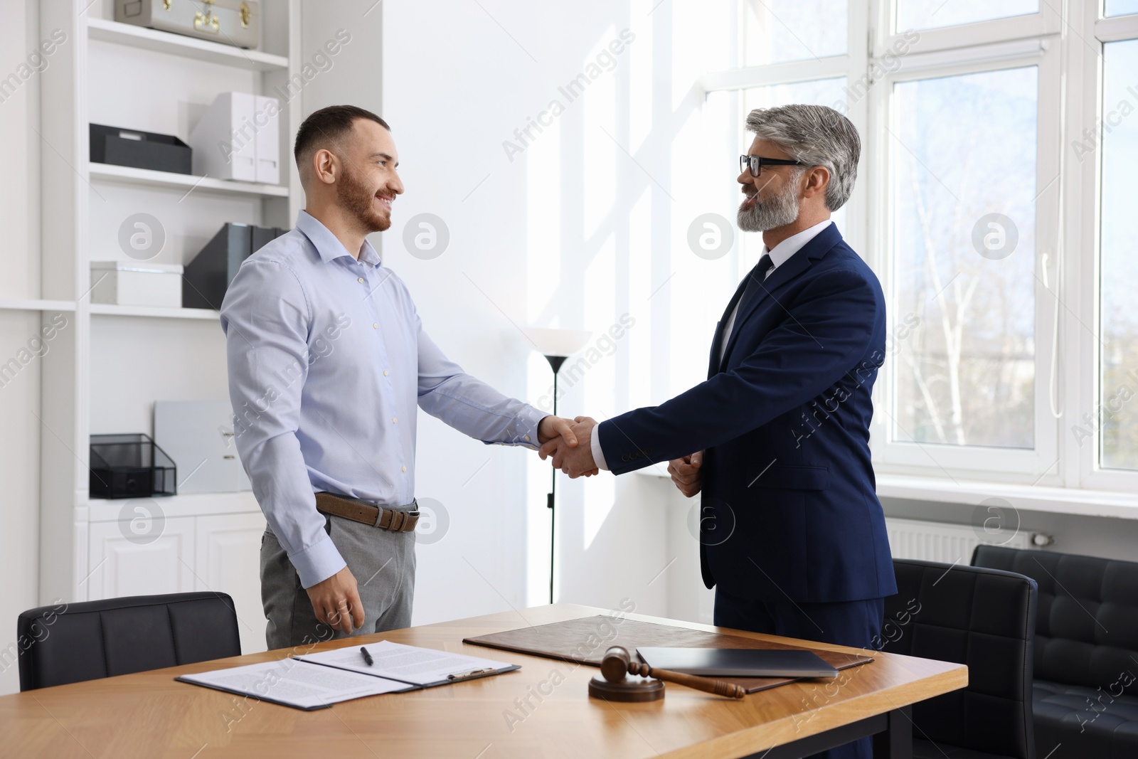 Photo of Notary shaking hands with client in office