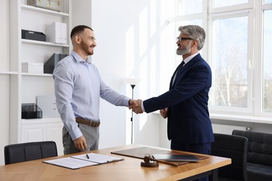 Notary shaking hands with client in office