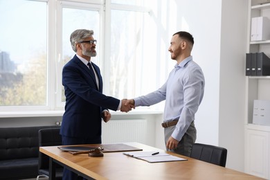 Notary shaking hands with client in office