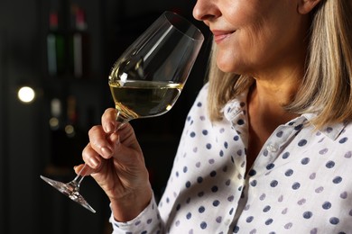 Professional sommelier tasting white wine indoors, closeup