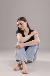 Photo of Beautiful young woman in stylish jeans on grey background