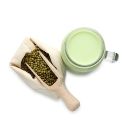 Photo of Fresh mung bean juice in mason jar, scoop and seeds isolated on white, top view