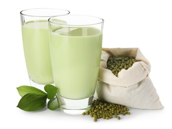 Photo of Fresh mung bean juice in glasses, seeds and green leaves isolated on white