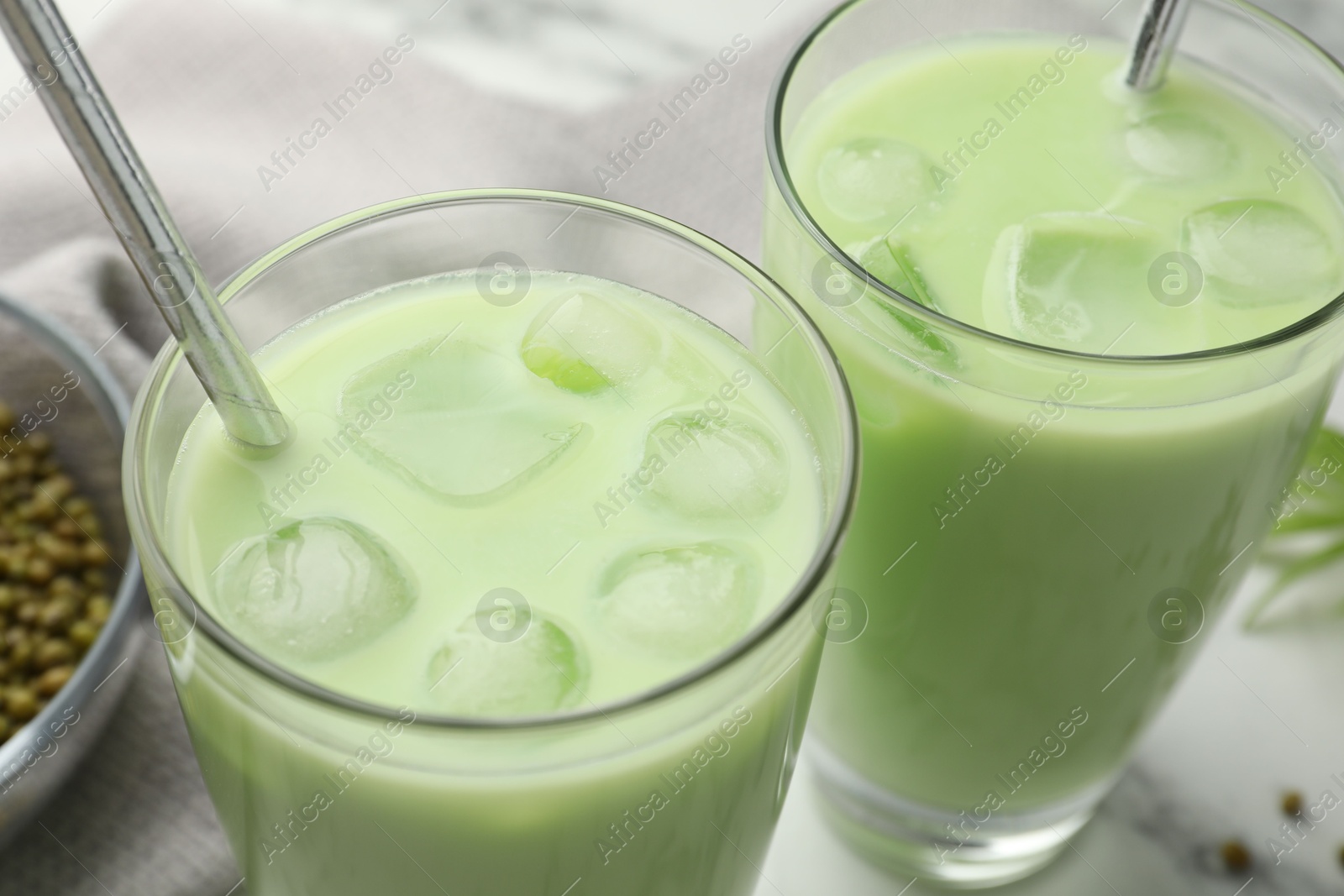 Fresh mung bean juice in glasses and seeds on table, closeup Photo of Fresh mung bean juice in glasses and seeds on table, closeup