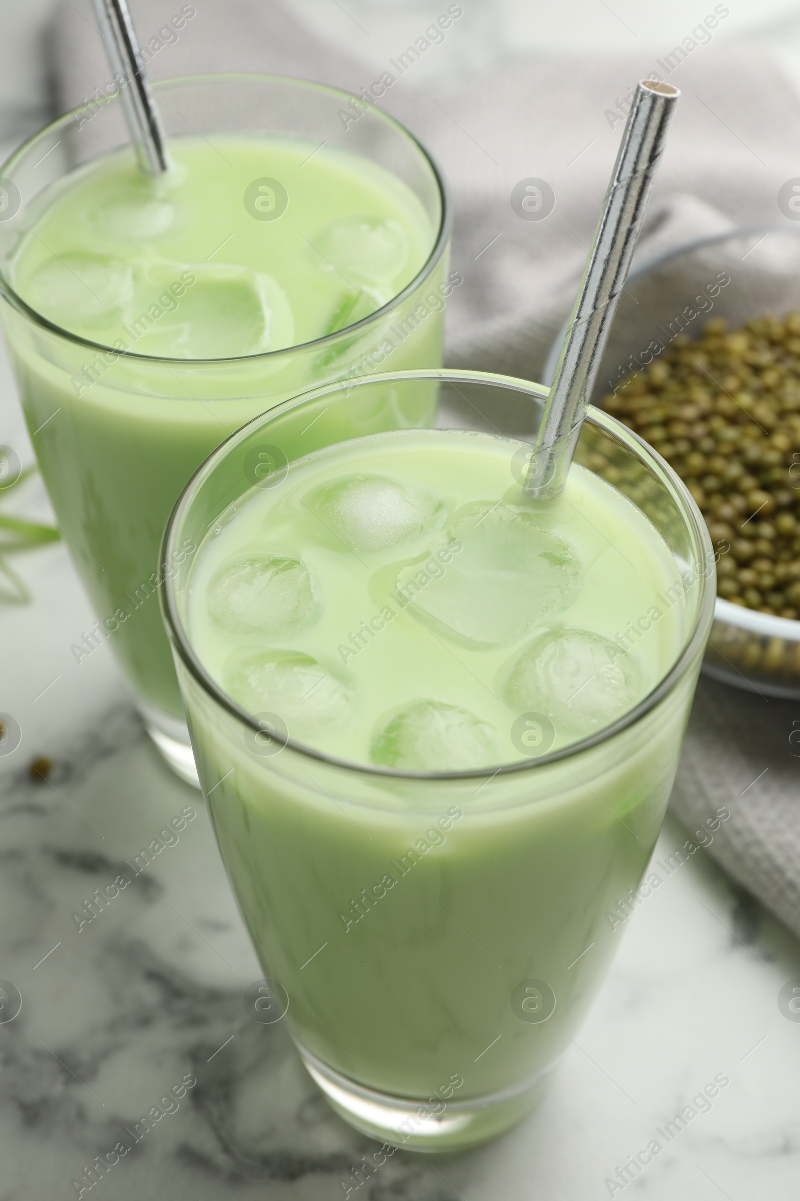 Fresh mung bean juice in glasses and seeds on white marble table, closeup Photo of Fresh mung bean juice in glasses and seeds on white marble table, closeup